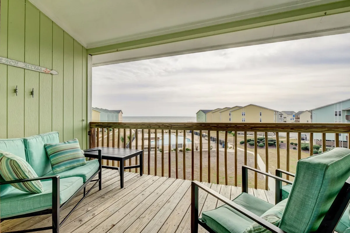 A tranquil, private deck with cozy seating overlooking the ocean and surrounding grounds. The perfect place to sip coffee or enjoy the sea breeze, with views that invite relaxation and contemplation.
